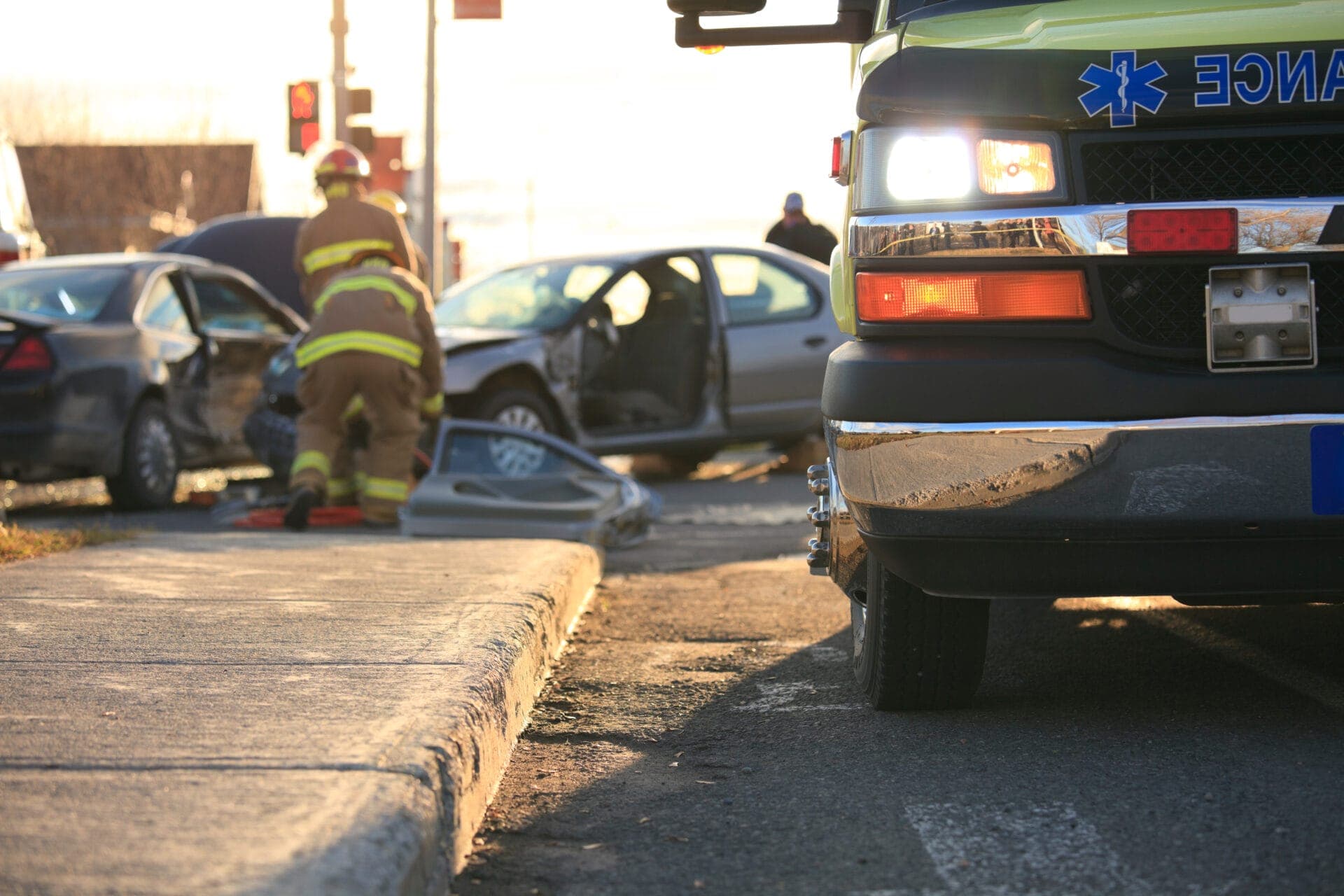 Emergency responders and ambulance at the scene of a two-car crash, illustrating the critical role of accurate crash data and timely eCall alerts in rescue operations.