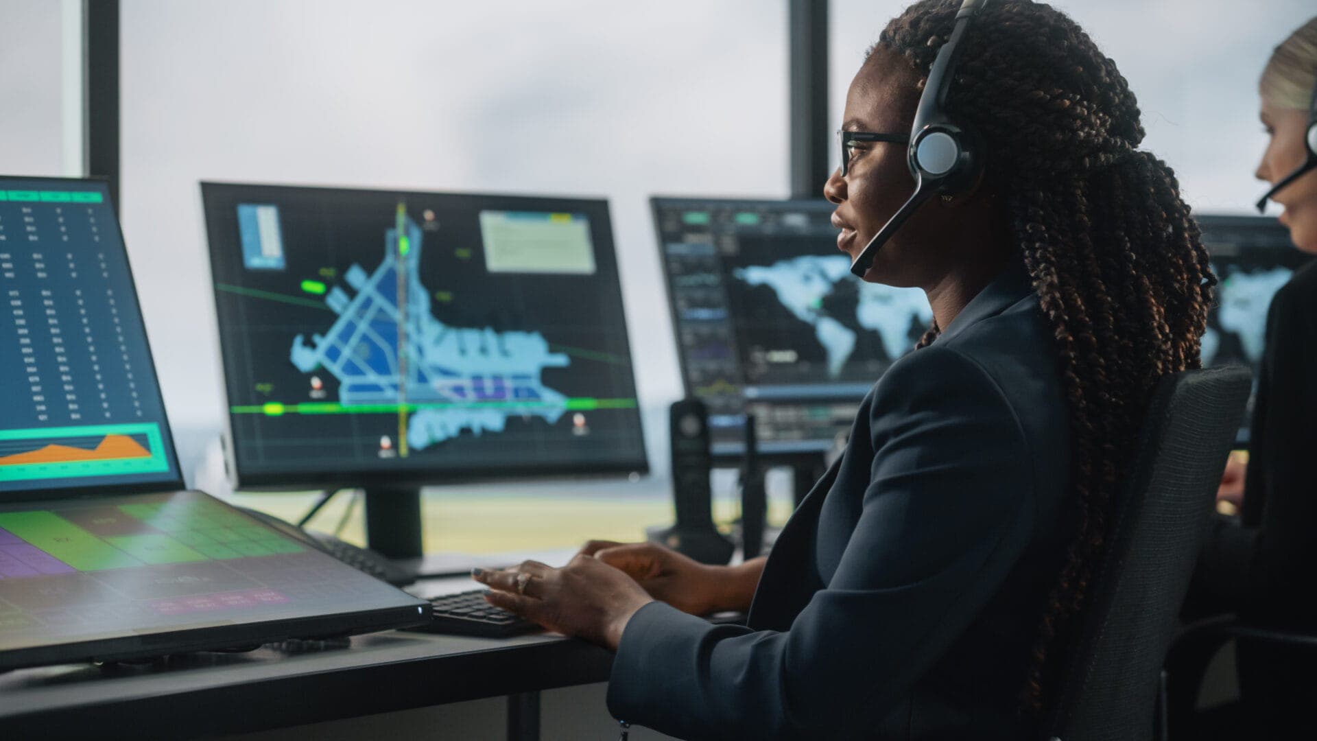 Close-up of an air traffic controller using multiple monitors, illustrating how eye tracking can measure focus and workload in multi-screen environments.