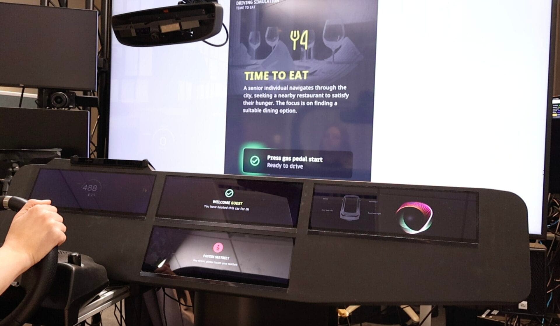 A driving simulator interface showing a dining scenario, used to evaluate driver behavior and intent through advanced in-cabin sensing technologies.